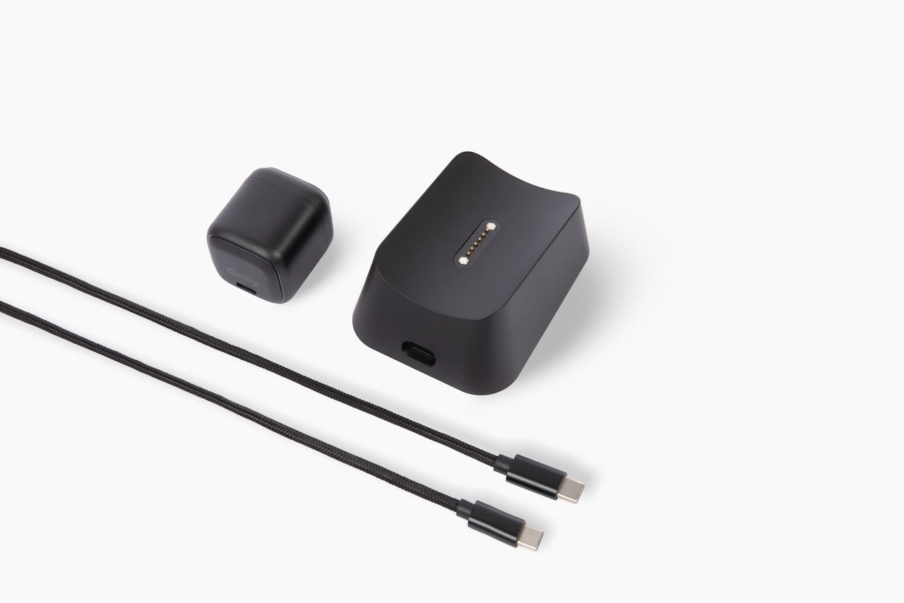 Black charging dock with pogo-pin connector, small USB-C power adapter, and two braided USB-C to USB-C cables.