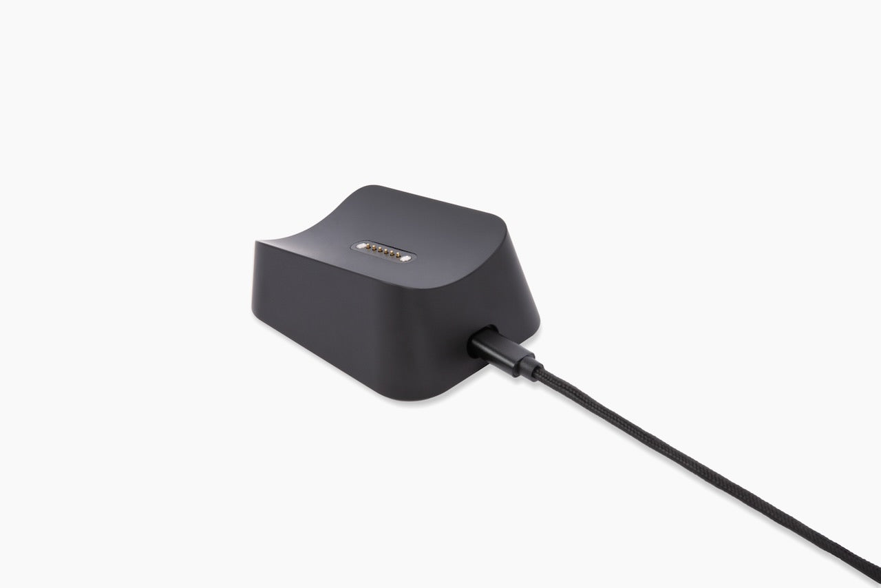 Black magnetic charging dock with gold contact pins and braided cable